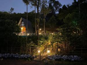 a house with lights in a garden at night at Vagamon leafmist frame cabin in Vagamon