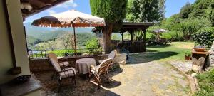 a patio with a table and chairs and an umbrella at CASALE SPOLETO in Spoleto