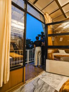 a man standing on a balcony looking out of a window at Vagamon leafmist frame cabin in Vagamon