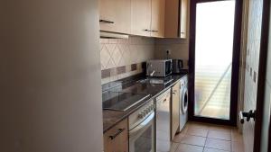 a small kitchen with a sink and a microwave at Spa Valley II experiences Penthouse con Piscina climatizada y Yacuzzi in Villanueva de Río Segura