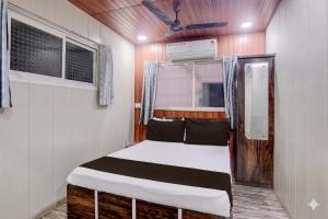 a small bedroom with a bed in a room at Hotel Garden Lodging And Boarding in Ulhāsnagar