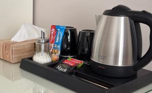 a black tray with a tea kettle and other items on a counter at Antonio Old Town Residence in Prešov +41 photos