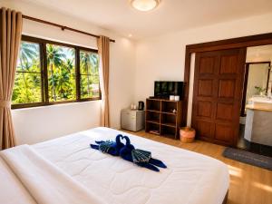 a bedroom with a bed with a blue ribbon on it at Villa Giacomelli Samui in Taling Ngam Beach