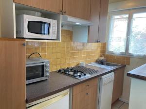 a kitchen with a microwave and a stove top oven at Tucaut in Toulouse