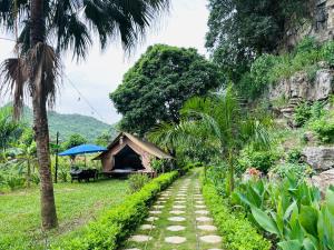 a tent next to a path with palm trees at Hen Camping- Coffee --------- Free if you have tent in Ninh Binh