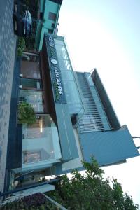 a tall building with a glass staircase in front of it at Gamagashree Hotel and Fine Dine in Sāgar