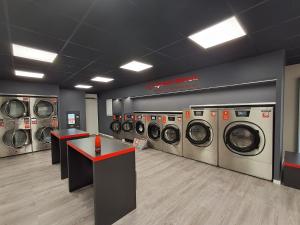 a laundry room with a row of washing machines at chambre d'hôte cosy L'AGHJA in Carbuccia