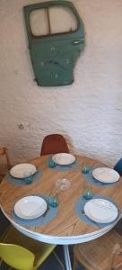 a wooden table with plates on top of it at Le Figuier , Domaine La Capitainerie in Bazoges-en-Pareds