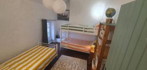 a small room with two bunk beds and a window at Le Figuier , Domaine La Capitainerie in Bazoges-en-Pareds