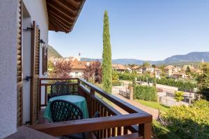 a balcony with two chairs and a view of a city at Stompferhof Erkerwohnung in Caldaro
