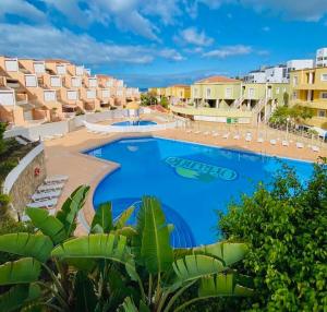 a large swimming pool in a resort with buildings at Orlando Costa Adeje in Adeje