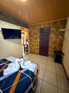 a bedroom with a bed and a door and a table at Cabinas Arenal Z-13 in Fortuna