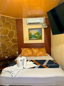 a small bedroom with a bed with towels on it at Cabinas Arenal Z-13 in Fortuna +30 photos