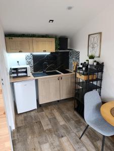 a small kitchen with a sink and a table at Dax Jardin Studio in Dax