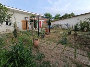 a garden with potted plants in front of a house at Dax Jardin Studio in Dax