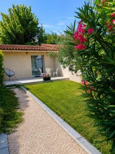 a garden with pink flowers and a house at Gîte Le Jasmin in Le Thor