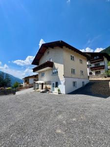 a large building on top of a gravel road at Apart Alpenflair 74 in Fliess