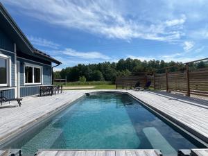 ein Swimmingpool mit Holzterrasse und ein Haus in der Unterkunft Spithami Pool House in Spithami