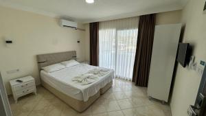 a bedroom with a bed and a large window at Yağmur Apart Otel in Didim +61 photos