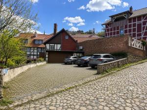 a parking lot with cars parked in front of a building at Ferienwohnungen an der alten Stadtmauer in Blankenburg