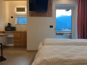 a bedroom with two beds and a view of a mountain at Liz Hotel & Apartments in Predazzo