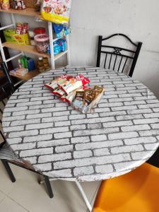 a white table with a black chair and a table with food at Hotel Sutera Maju in Kota Kinabalu