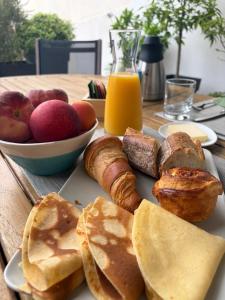 a plate of breakfast food with bread and pastries on a table at Ty-Aganisia Breizh in Perros-Guirec