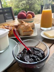 a table with a bowl of jam and a plate of food at Ty-Aganisia Breizh in Perros-Guirec +20 photos