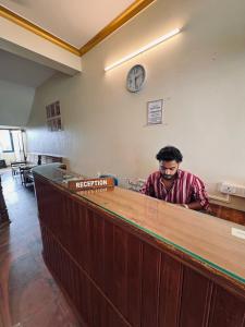 a man standing at the counter of a restaurant at hello varkala beach view balcony resort in Varkala