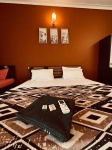a bedroom with a bed with a remote control on it at hello varkala beach view balcony resort in Varkala