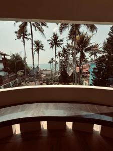 a window with a view of palm trees and the ocean at hello varkala beach view balcony resort in Varkala +80 photos