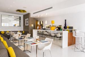 ein Restaurant mit Tischen und Stühlen und einer Bar in der Unterkunft Chill Hotel Seminyak in Seminyak