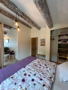 a bedroom with a large bed with purple sheets at Au Clair Ventoux B & B - SPA in Saint-Didier