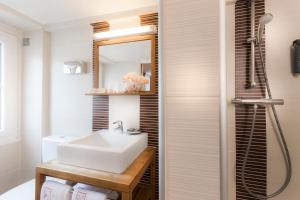 a bathroom with a white sink and a shower at Hôtel Jeanne d'Arc Le Marais in Paris +67 photos