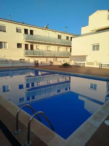 a swimming pool in front of a building at Apartamento Noenil in L'Estartit +17 photos