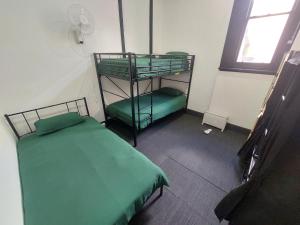 a small room with two bunk beds and a window at The Vine & Lamb in Saint Arnaud