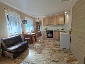 a kitchen with a couch and a table and a refrigerator at San Lorenzo in Lopar