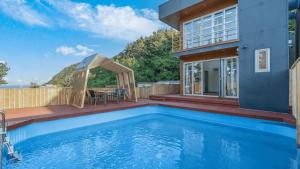 a house with a swimming pool and a gazebo at Uljin 207 Mile Pool Villa in Uljin