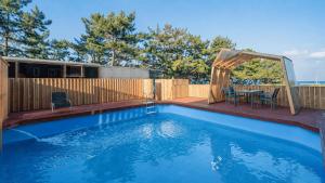 a swimming pool with a gazebo and a table at Uljin 207 Mile Pool Villa in Uljin