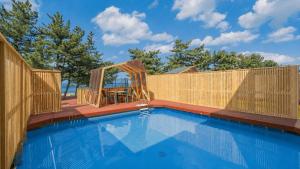 a swimming pool with a wooden fence around it at Uljin 207 Mile Pool Villa in Uljin +15 photos