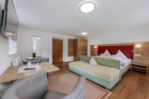 a living room with a bed and a table and chairs at Landhaus Waldesruh in Oetz