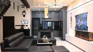 a living room with a black leather couch and a tv at Meria town attock in Attock