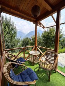a porch with chairs and a table with a view at Cedar Forest BnB Villa in Kasol