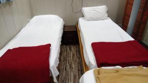 two beds sitting next to each other in a room at Hotel Garden Lodging And Boarding in Ulhāsnagar