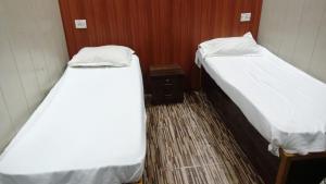 two beds in a small room with at Hotel Garden Lodging And Boarding in Ulhāsnagar