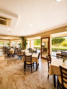 a restaurant with tables and chairs and windows at Kalias Hotel in Vasiliki