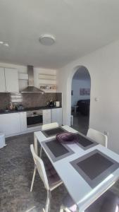 a kitchen with a table and chairs in a room at Silver Rose apartman in Veliko Gradište