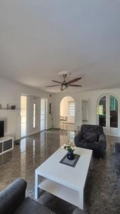a living room with a table and a ceiling fan at Silver Rose apartman in Veliko Gradište