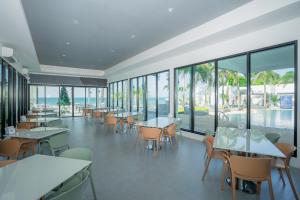 a restaurant with tables and chairs and windows at เจ้าหลาว ซี บรีส รีสอร์ท in Ban Mu Dut
