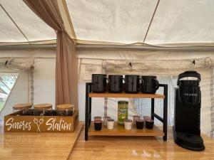 a stand with cups and a coffee maker in a tent at Evergreen Escape in Brush Prairie